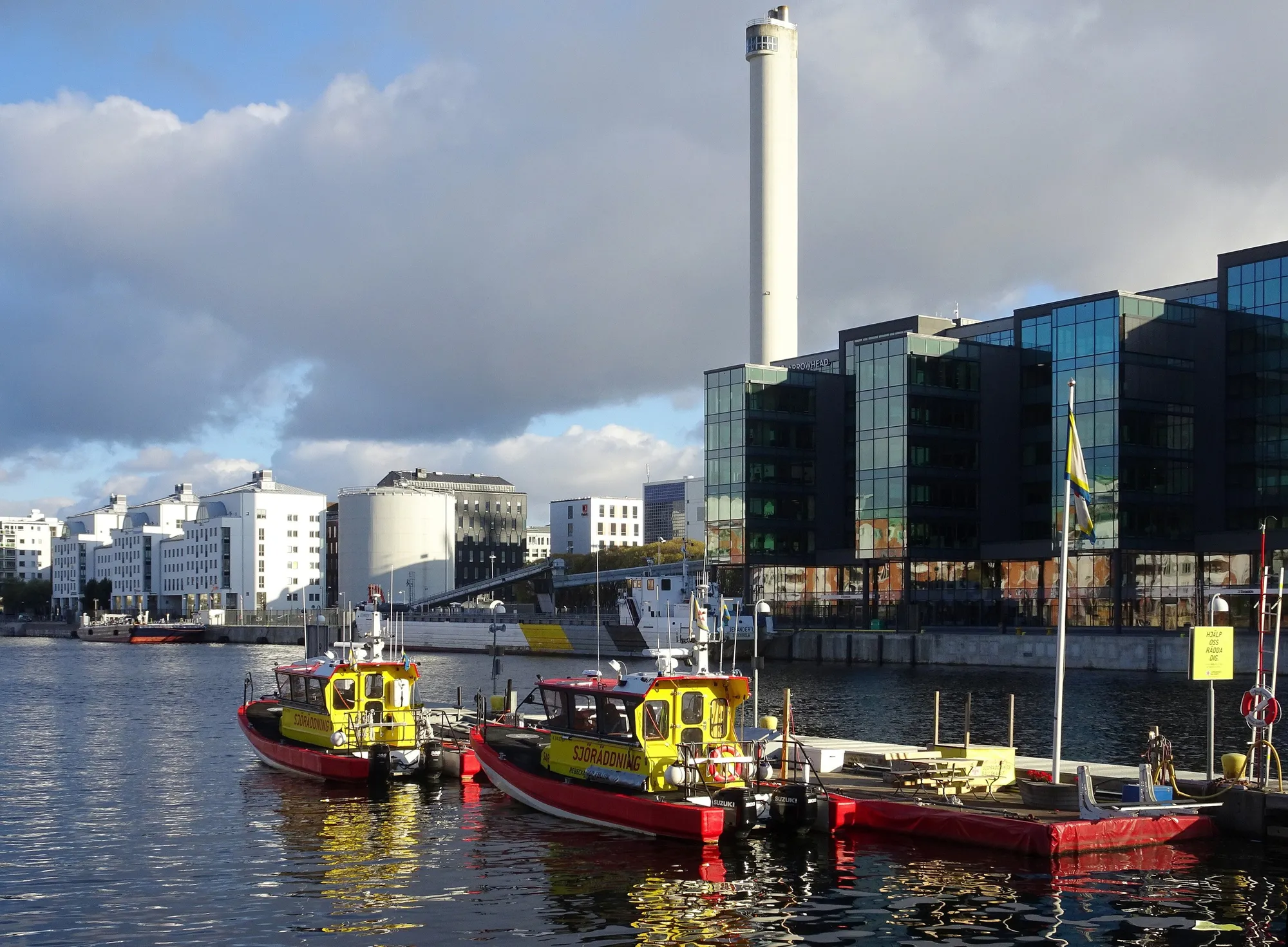 Bateaux à quai à Hammarby Sjöstad, devant la cheminée de l’usine de chaleur