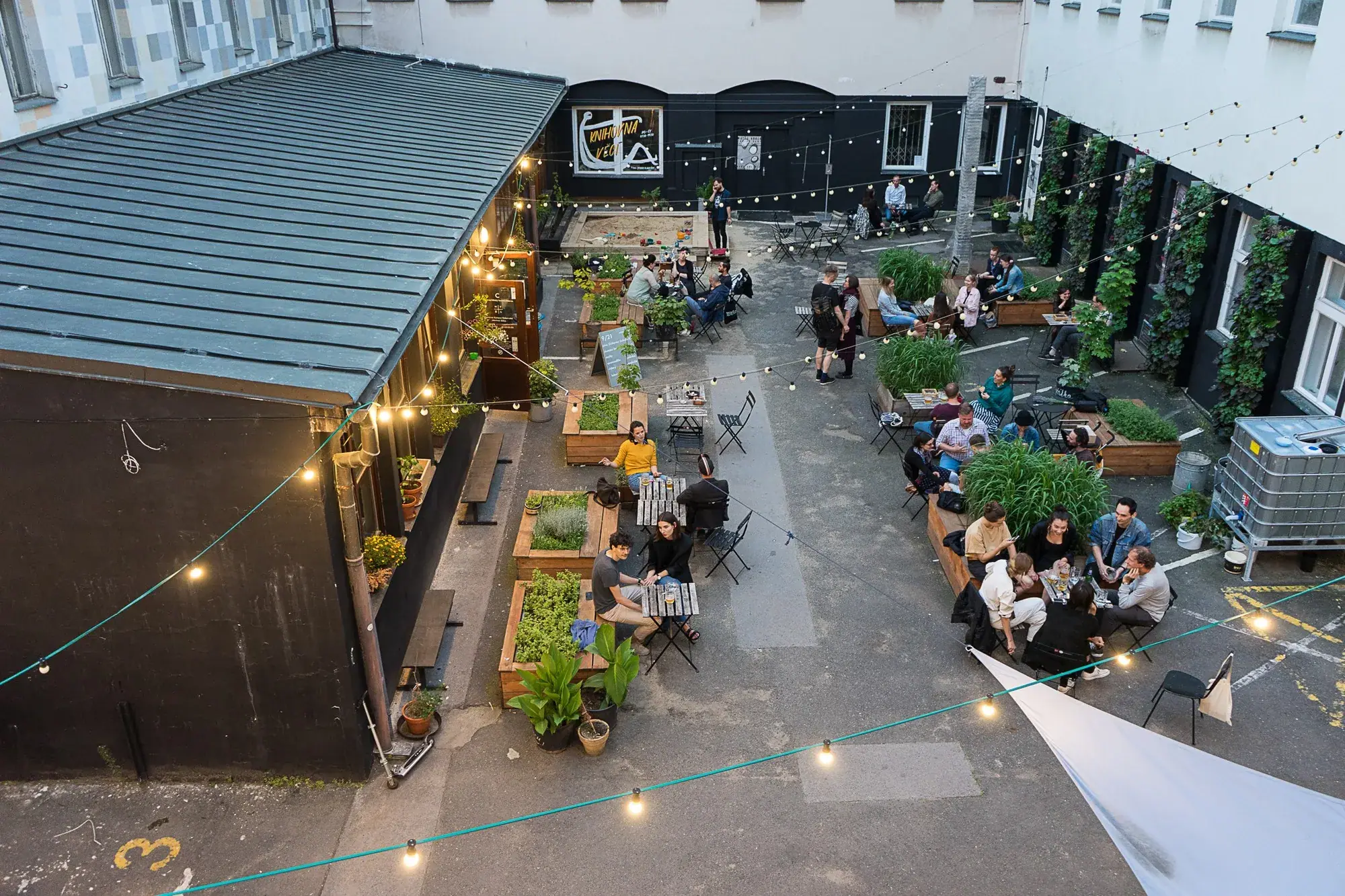 La cour du Kampus Hybernská, ses tables et ses bacs plantés